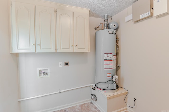 laundry room featuring electric dryer hookup, cabinets, gas water heater, hookup for a washing machine, and a textured ceiling