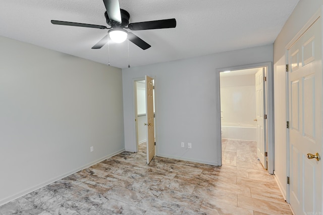 unfurnished bedroom with a textured ceiling, ensuite bathroom, and ceiling fan