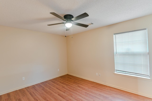 spare room with ceiling fan, a textured ceiling, and light hardwood / wood-style flooring