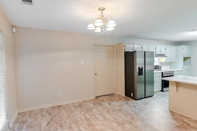 kitchen featuring appliances with stainless steel finishes, a textured ceiling, decorative light fixtures, a chandelier, and white cabinetry