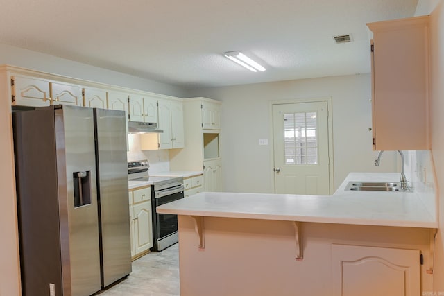 kitchen with sink, appliances with stainless steel finishes, light hardwood / wood-style floors, kitchen peninsula, and a breakfast bar area