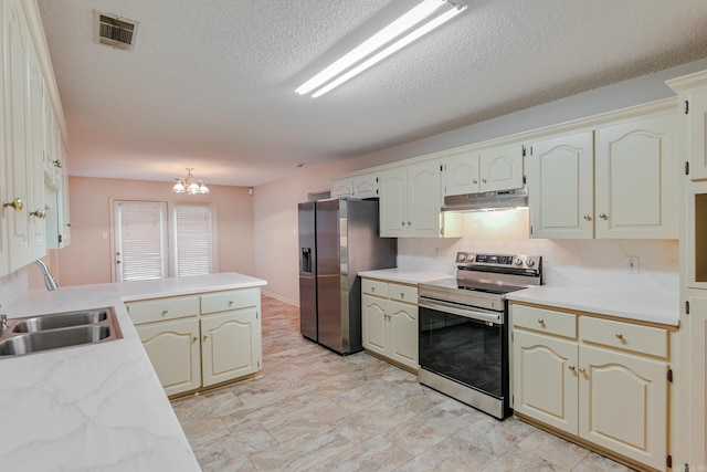 kitchen featuring sink, a textured ceiling, kitchen peninsula, stainless steel appliances, and a chandelier