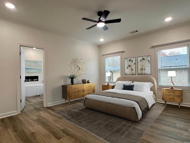 bedroom with multiple windows, dark wood-type flooring, and ceiling fan