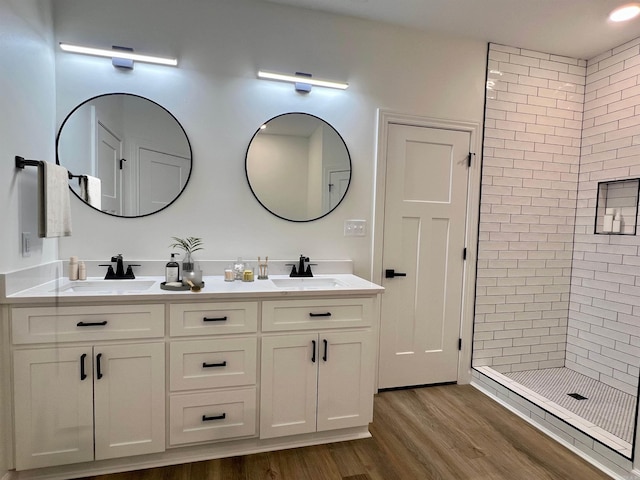 bathroom featuring hardwood / wood-style floors, vanity, and tiled shower