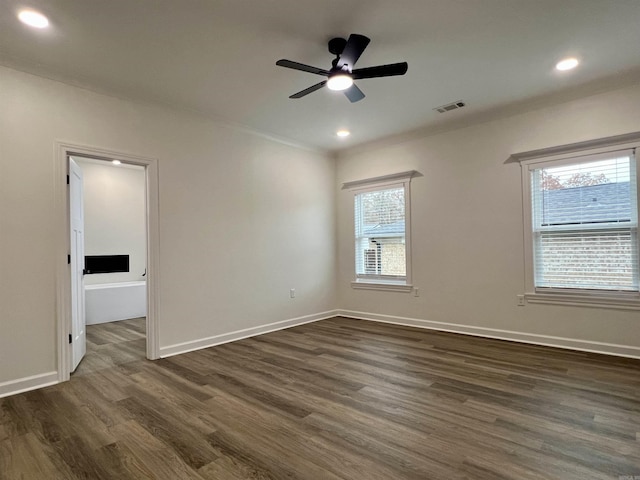 spare room with dark hardwood / wood-style floors, plenty of natural light, and ceiling fan