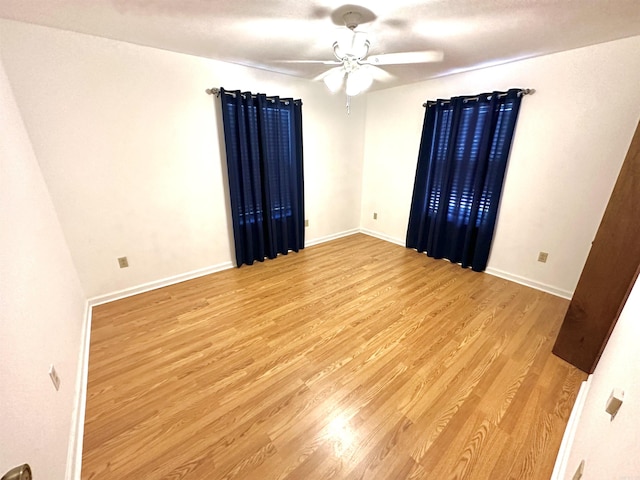 empty room featuring ceiling fan and light hardwood / wood-style floors