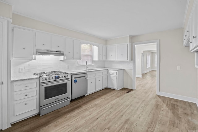 kitchen with sink, light hardwood / wood-style flooring, light stone countertops, white cabinetry, and stainless steel appliances