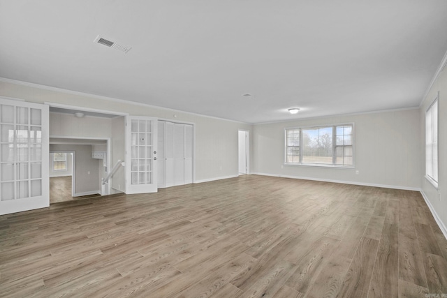 unfurnished living room featuring crown molding, french doors, and light wood-type flooring