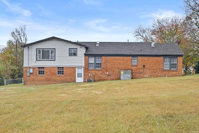 back of property featuring a yard and central air condition unit