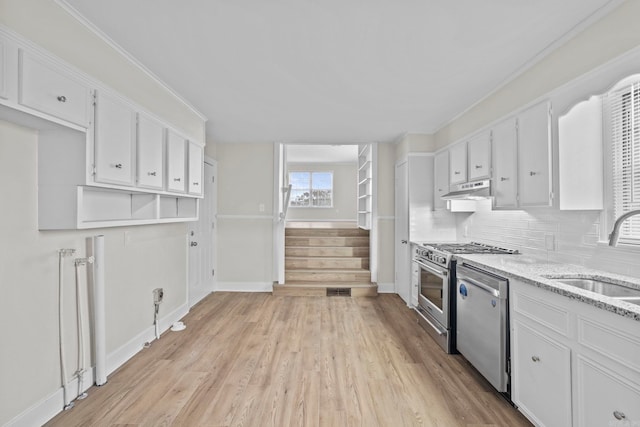 kitchen featuring white cabinets, light wood-type flooring, sink, and appliances with stainless steel finishes