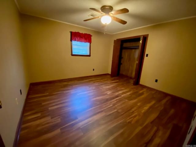 spare room with crown molding, dark hardwood / wood-style flooring, and ceiling fan