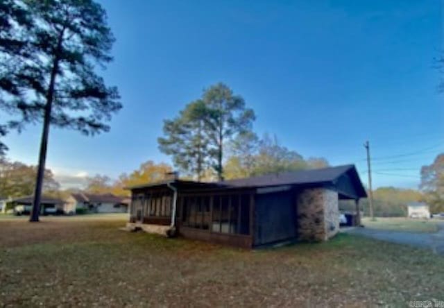 view of side of property featuring a sunroom and a yard