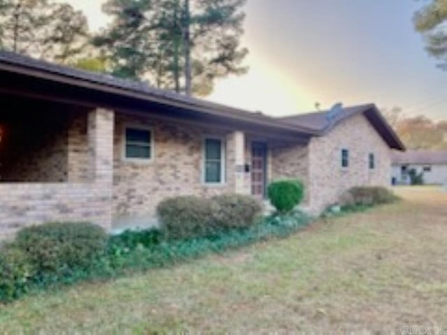 property exterior at dusk with a lawn