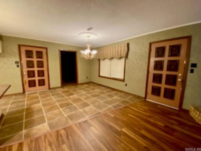 unfurnished dining area featuring hardwood / wood-style floors, a notable chandelier, and crown molding