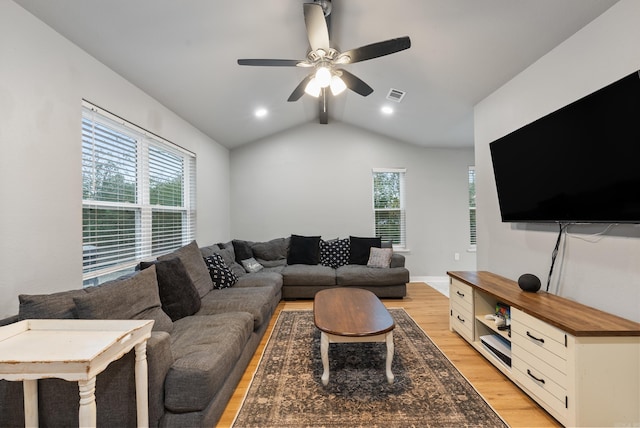 living room featuring ceiling fan, light hardwood / wood-style floors, a wealth of natural light, and vaulted ceiling