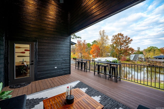 wooden terrace featuring exterior bar and a water view