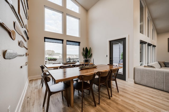 dining space featuring a high ceiling and light wood-type flooring