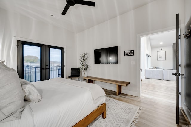 bedroom featuring access to outside, ceiling fan, french doors, and light wood-type flooring