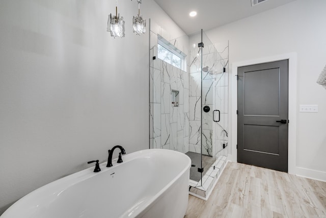 bathroom featuring a chandelier, hardwood / wood-style flooring, and independent shower and bath