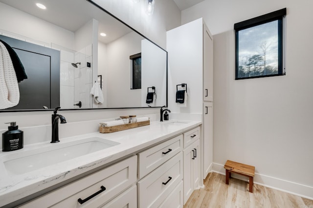 bathroom featuring tiled shower, vanity, and hardwood / wood-style flooring