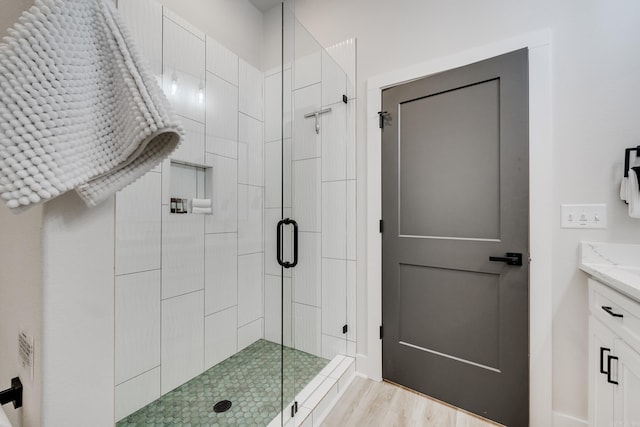 bathroom featuring vanity, an enclosed shower, and hardwood / wood-style flooring