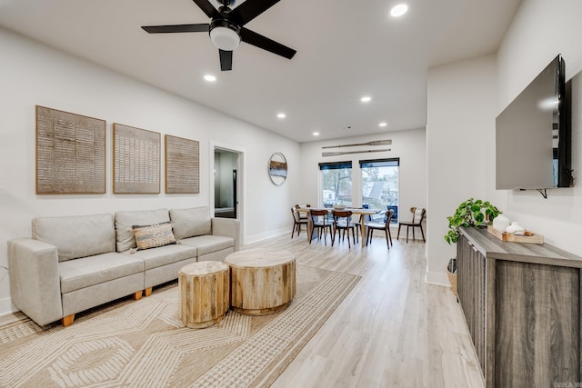 living room with ceiling fan and light hardwood / wood-style flooring