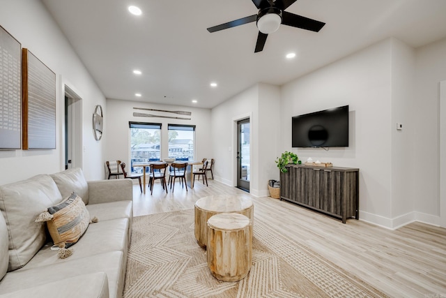 living room with ceiling fan and light hardwood / wood-style flooring