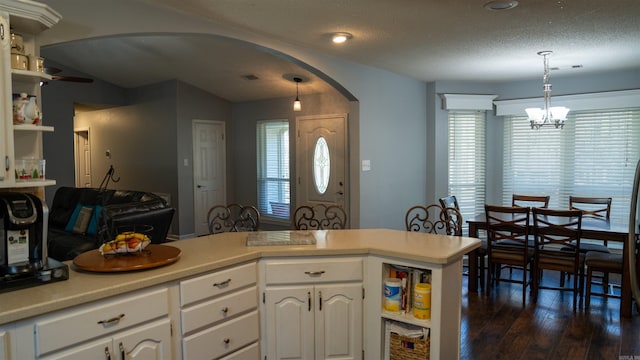 kitchen featuring dark hardwood / wood-style flooring, white cabinetry, and hanging light fixtures