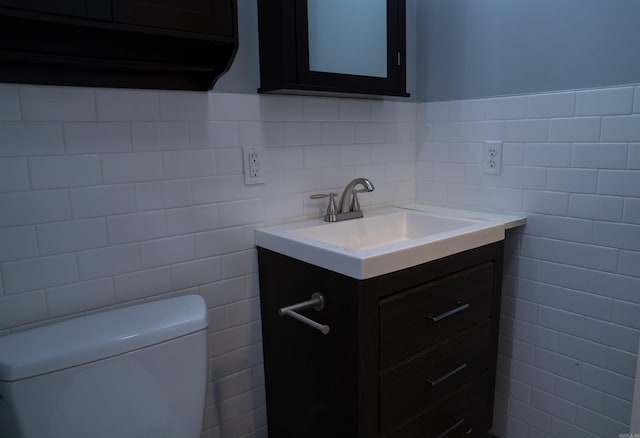 bathroom with vanity, tile walls, and toilet