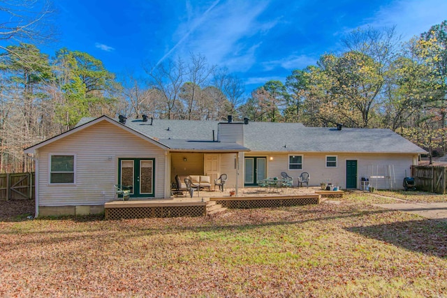 rear view of property with outdoor lounge area, french doors, a wooden deck, and a lawn