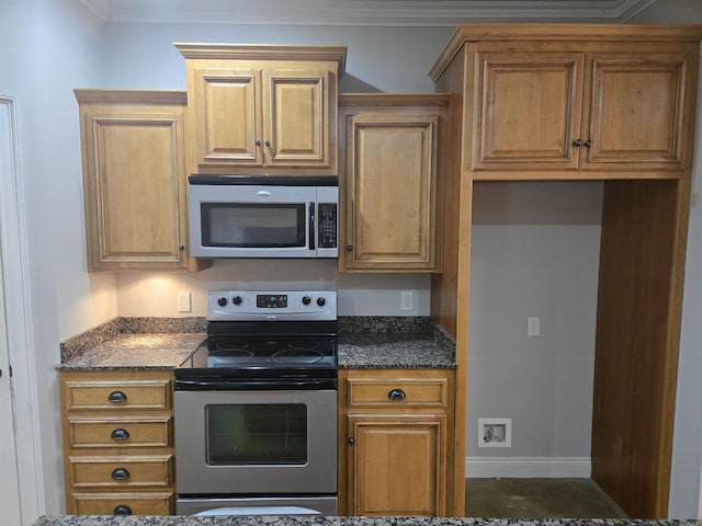 kitchen with dark stone counters, crown molding, and stainless steel appliances