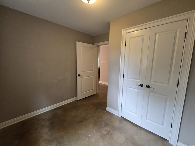 unfurnished bedroom with a closet and concrete floors