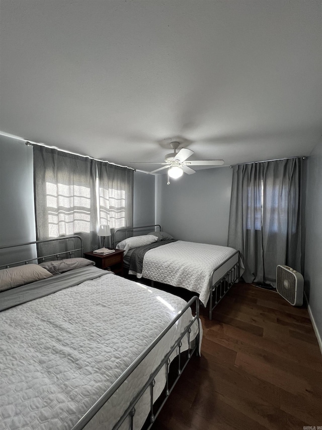 bedroom with ceiling fan and dark wood-type flooring