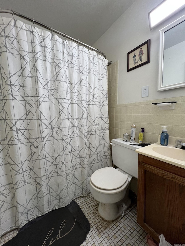 bathroom featuring tile patterned floors, a shower with curtain, vanity, tile walls, and toilet