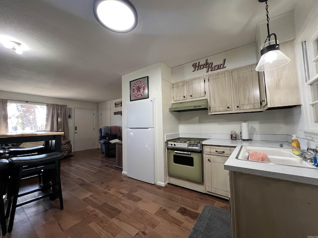 kitchen with dark wood-type flooring, white refrigerator, sink, hanging light fixtures, and stainless steel electric range oven