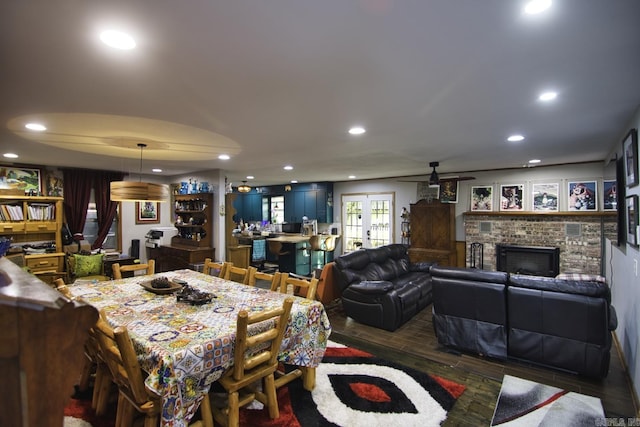 dining space with a fireplace, french doors, dark hardwood / wood-style flooring, and ceiling fan