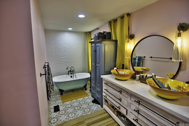 bathroom with hardwood / wood-style flooring, vanity, and a tub