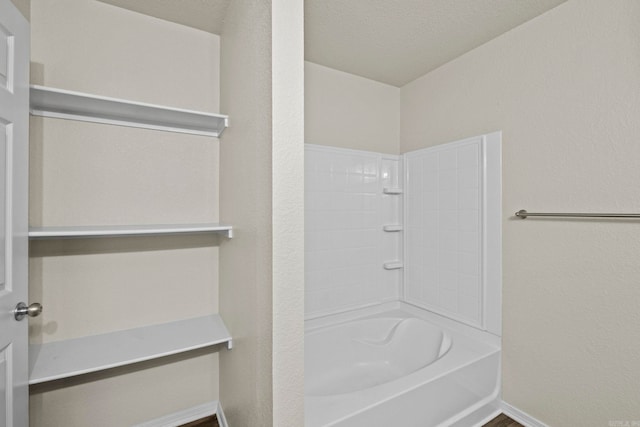 bathroom featuring shower / bath combination and a textured ceiling