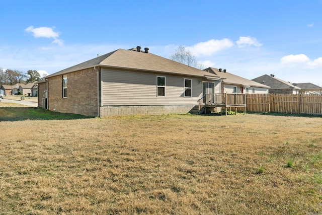 back of property featuring a yard and a deck