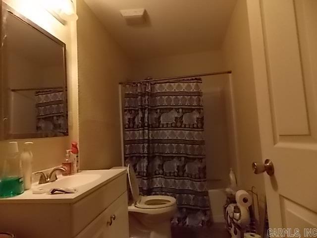 full bathroom with vanity, toilet, and shower / bathtub combination with curtain