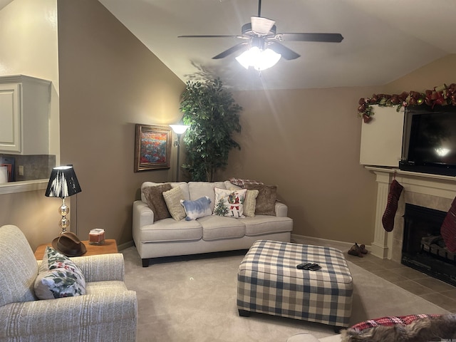 carpeted living room with vaulted ceiling, ceiling fan, and a tiled fireplace