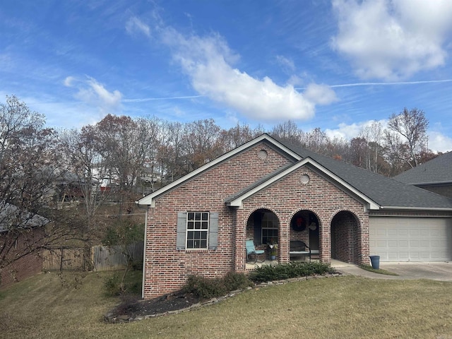 view of front of property featuring covered porch, a front yard, and a garage