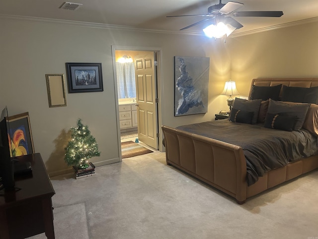 bedroom with ceiling fan, light colored carpet, crown molding, and connected bathroom