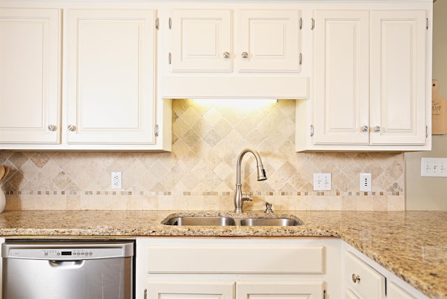 kitchen with dishwasher, white cabinets, sink, decorative backsplash, and light stone counters