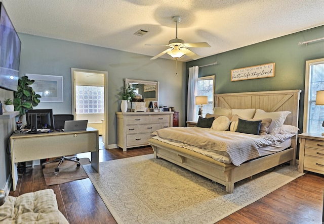 bedroom featuring a textured ceiling, ceiling fan, and dark wood-type flooring