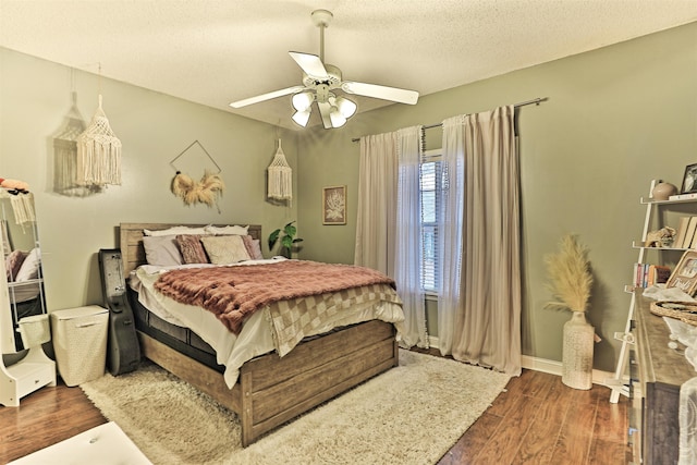 bedroom featuring a textured ceiling, ceiling fan, and dark hardwood / wood-style floors