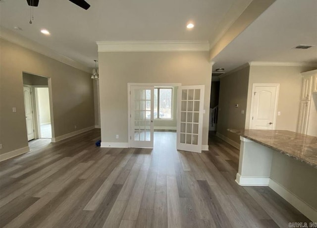 unfurnished living room featuring french doors, dark hardwood / wood-style flooring, ceiling fan, and crown molding