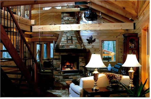 living room featuring vaulted ceiling with beams, wood walls, and a fireplace