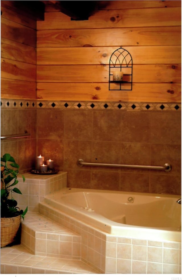 bathroom with wooden walls and tiled tub