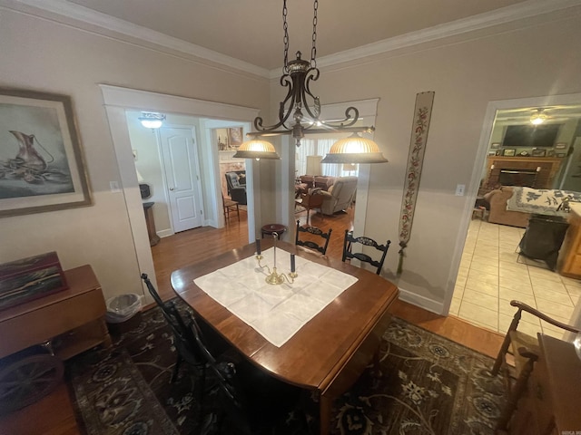 dining space featuring wood-type flooring, an inviting chandelier, and crown molding